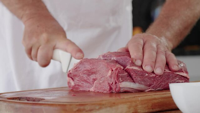 Cook at Traditional Churrasco Brazilian Barbecue. Preparing and cutting Ancho meat. Home Grill from Brazil
