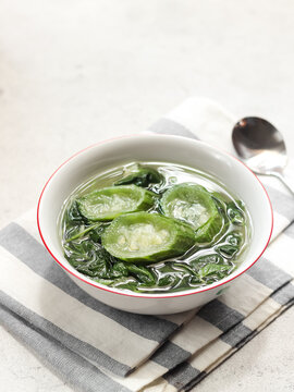 Sayur bening bayam oyong or clear soup of spinach and luffa vegetables. Serve in white ceramics bowl. Selective focus