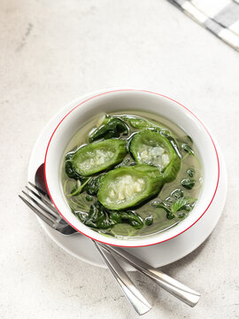 Sayur bening bayam oyong or clear soup of spinach and luffa vegetables. Serve in white ceramics bowl. Selective focus