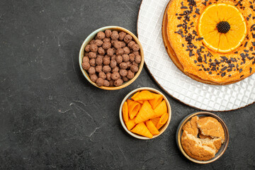 Fototapeta na wymiar top view tasty sweet pie with orange slices on a dark grey desk sweet pie dessert tea biscuit cake sugar
