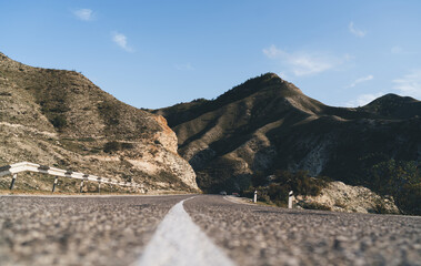 Asphalt road with divider white line in mountains