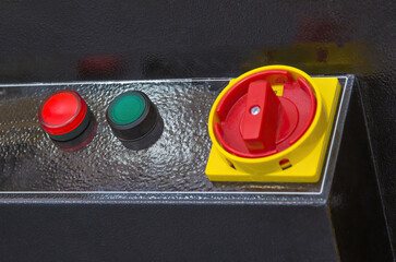 Fragment of the control panel with a red rotary switch on a yellow base and red and green indicators