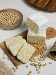 Raw Tempeh or Tempe. Tempeh Slices on Wooden White Background. Tempe Made From Fermented Soybeans