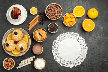 top view yummy cookies with cup of tea and orange slices on dark desk cake pie sugar dessert biscuit tea