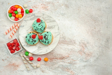 top view yummy cream cakes with colorful candies on white background dessert tea cake biscuit sweet cream