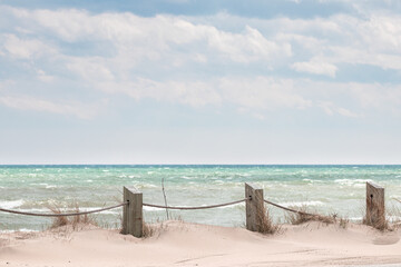 Hazy post and rope on beach with sunny sky