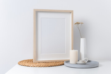 Blank wooden portrait picture frame mockup in white room interior, mock up with copy space