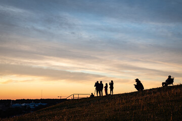 Sihouettes of a group of people gathered to witness the sunrise.