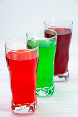 front view colorful fruity juices inside long glasses on the white background juice drink cocktail fruits