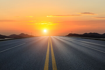 Straight asphalt road and mountain with sky clouds background at sunset