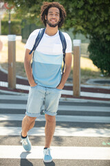 smiling young man with headphones on the street