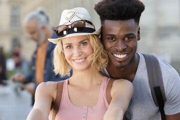 mixed couple taking a selfie with a smartphone
