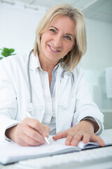 portrait of smiling mature doctor in office