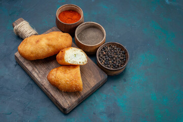 front view delicious pies with meat filling and seasonings on the dark blue background dough pie bread bun food bake