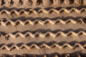 Car tire tracks on the sand in the desert
