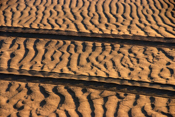 Car tire tracks on the sand in the desert
