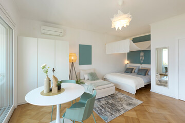 Studio with one double bed, one single bed. There is also a small white kitchen