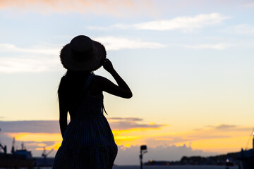 Fototapeta premium Silhouette of travel woman look at the sunset view