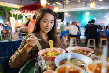 Woman enjoy her Thai noodle at Thai restaurant
