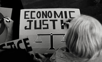 Senior activist preparing protest banners against financial crisis - Economic justice activism...