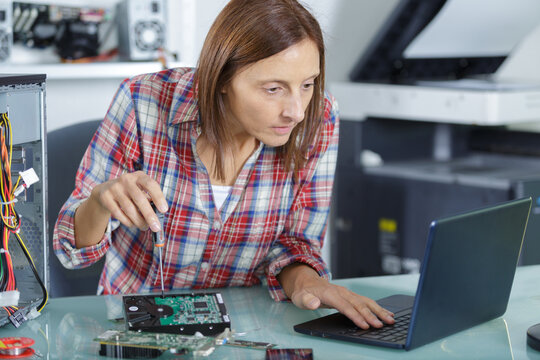 a woman unscrewing a laptopp