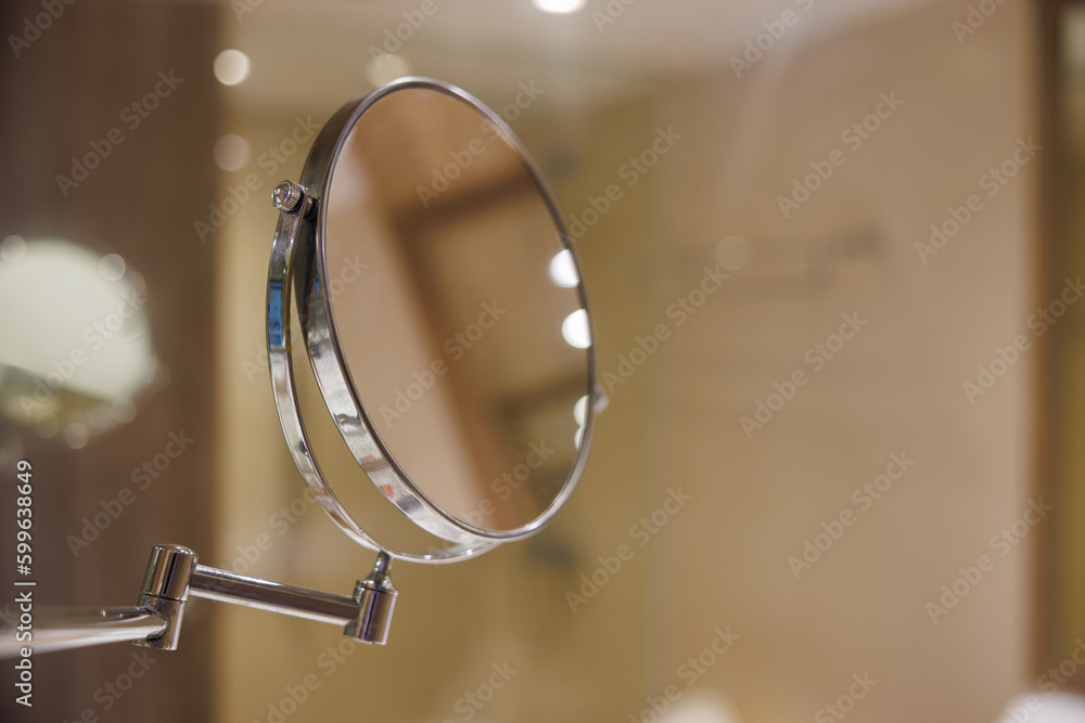 Wall mural round makeup mirror in hotel bathroom.