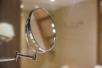 round makeup mirror in hotel bathroom.