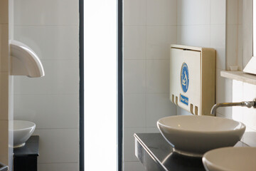 white plastic diaper table on brown ceramic wall in toilet. Baby diaper table in a public restroom