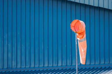 wind sock with metal factory as background.