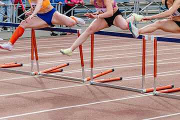 three woman runner running together 100 meters hurdles race in summer athletics championships