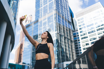 Fototapeta na wymiar Confident sportswoman taking self portrait on smartphone