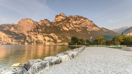 Fototapeta na wymiar City of Riva del Garda by Garda lake in Italy. View from the lake shore