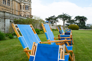 Row of canvas deck chairs seen within the grounds of a once stately home now turned into a luxury...