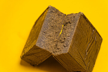 Chemdawg filtered hash. Medical marijuana extraction super dry hashish high quality cannabis pollen on a yellow background.