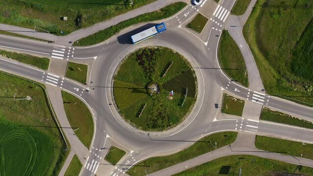 Roundabout intersection road traffic with many vehicles, aerial shot from drone pov