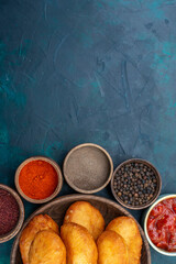 top view delicious pies with meat filling inside brown plate with seasonings on dark-blue desk dough pie bread bun food