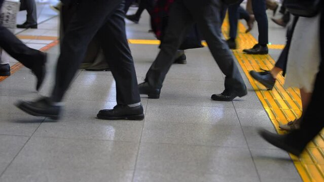 Footsteps through the streets as Japanese workers make their way to their jobs. The morning rush in Japan is a sight to behold, with many feet shuffling and scurrying on their way to work.