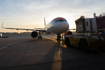 A jet bridge connecting to an airplane at sunset