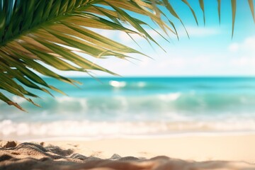 Fototapeta na wymiar Summer sandy beach with blur ocean on background. Palm leaves on foreground