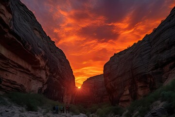 dramatic fiery sunset against the backdrop of canyon, with silhouetted figures trekking through the scene, created with generative ai