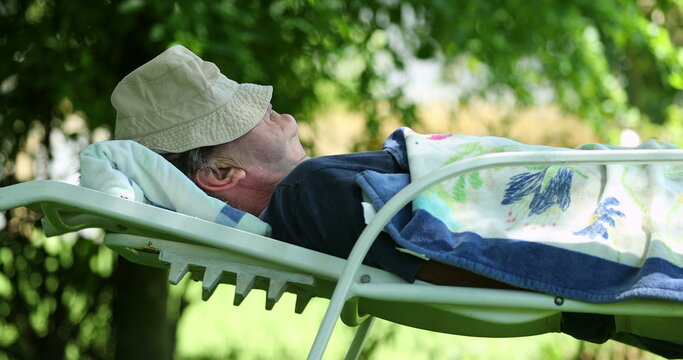 Older Man Taking A Nap Outside In Nature. Senior Retired Person Sleeping Under Tree