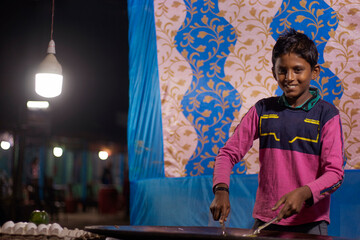 Indian boy cooking noodles at Local shop