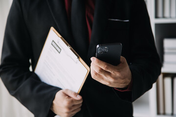 Businessman or job seeker review his resume on his desk before send to finding a new job with pen, necktie, glasses and digital tablet.