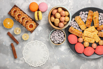 top view delicious sweet bagels with crackers cookies macarons and cup of tea on the white desk biscuit cookie sugar sweet