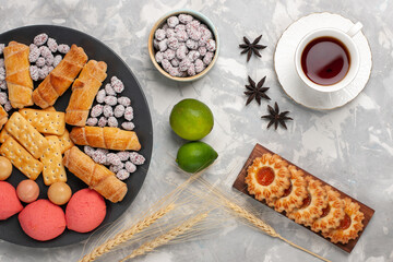 top view delicious sweet bagels with crackers lemon and cup of tea on white desk biscuit cookie sugar sweet