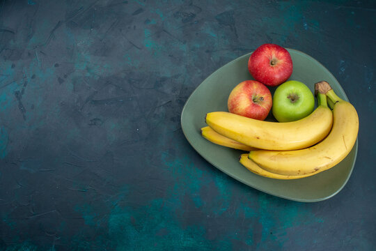 top view different fruit composition apples and bananas on the dark blue desk fruit fresh mellow exotic tropical