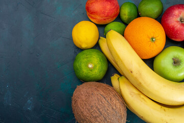 top view different fruit composition bananas tangerines apples on the dark-blue desk fruit fresh mellow ripe color vitamine - obrazy, fototapety, plakaty