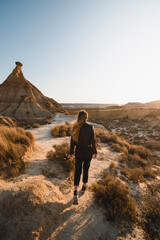girl with urban outfit walking at sunset in the desert of the Bardenas reales in Navarra