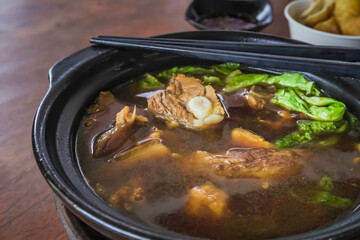 Close-up Claypot Cooked Bak kut teh or Bakut is a pork rib dish cooked in broth, served in Batam, Malaysia and Singapore. Malaysian stew of pork and traditional chinese herbal soup. Healthy Food