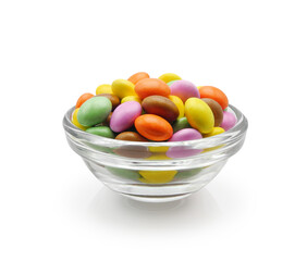 Small colorful chocolate candy dragee in glass bowl isolated on white background